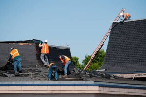 Workers repairing a building's roof, showcasing commercial construction services in action.