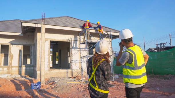Team of workers engaged in roof repairs on a commercial building, highlighting construction services.