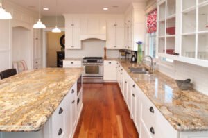 A modern kitchen featuring granite countertops and white cabinets, showcasing a Custom Kitchen Design for a stylish cooking space.