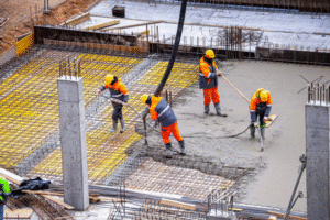 AA man and woman operate a construction machine for slab and foundation repair on a house.