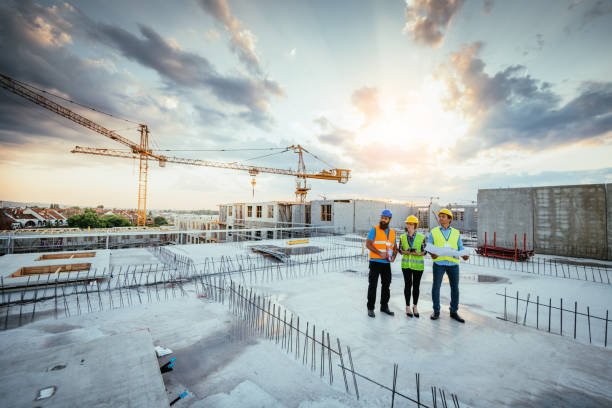 Three construction workers on a site, engaged in full-service concrete construction activities.