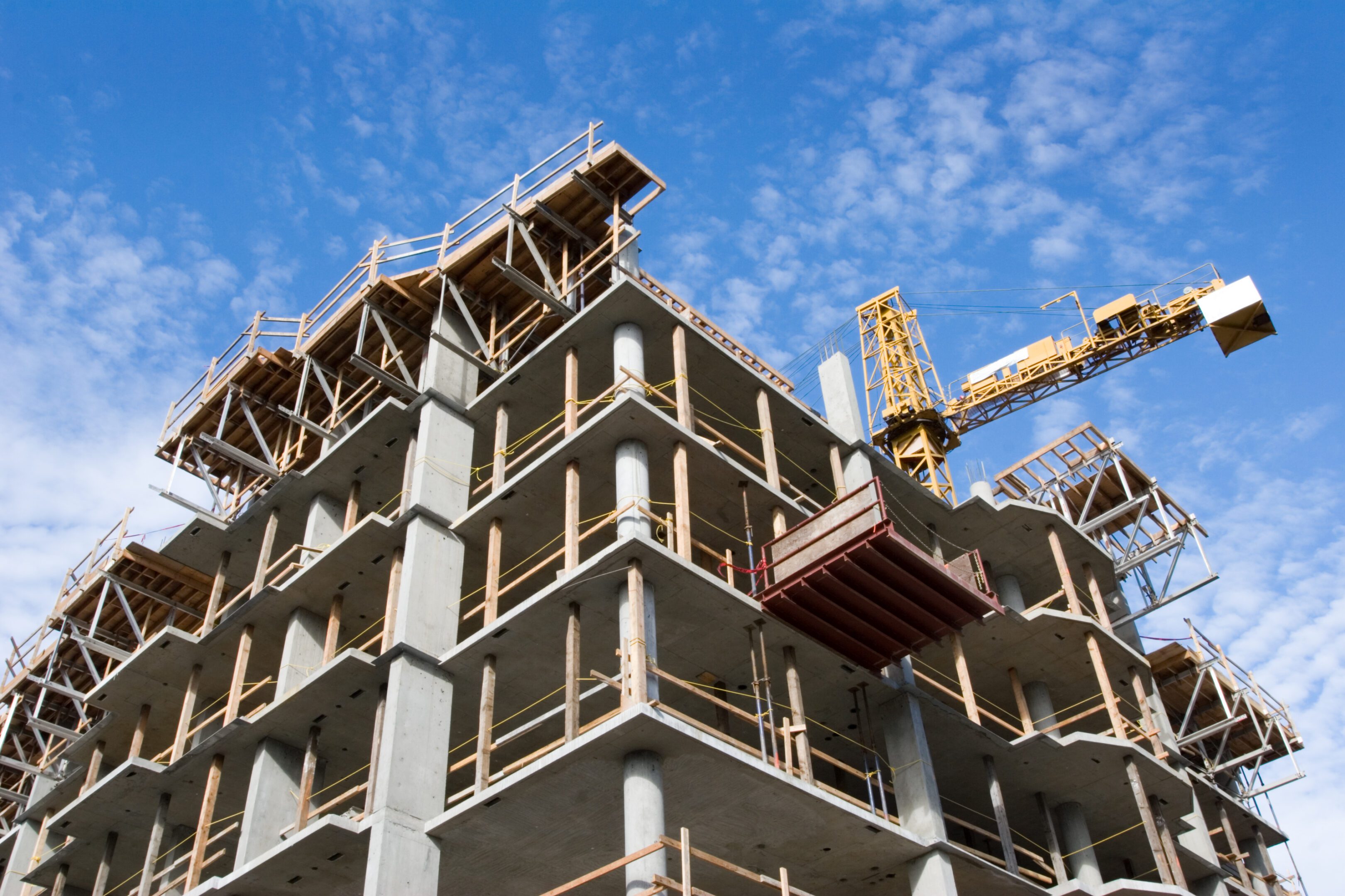 Reinforced steel &amp; concrete building under construction.  Safety guard rails, flyforms and tower crane